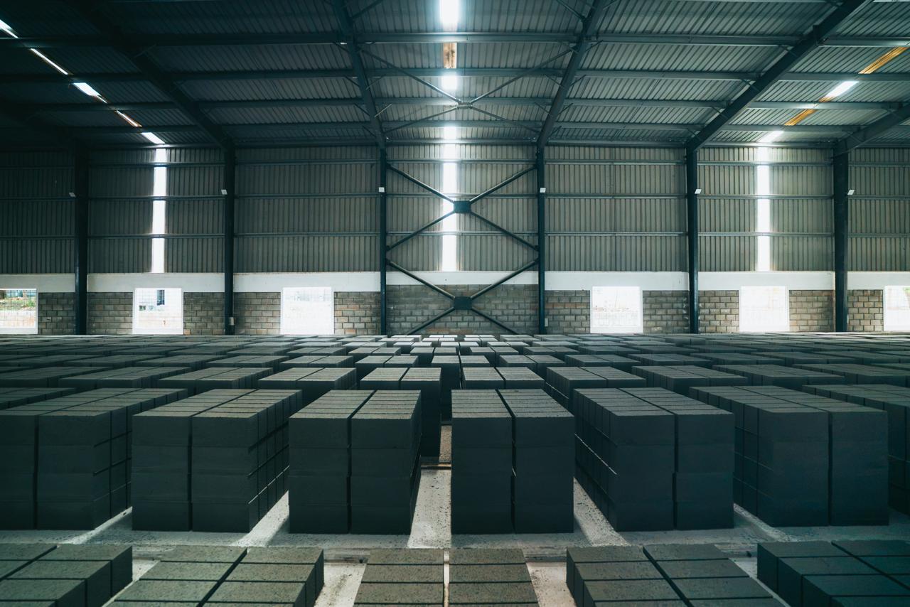 Rows of stacked concrete blocks curing inside the APCO factory