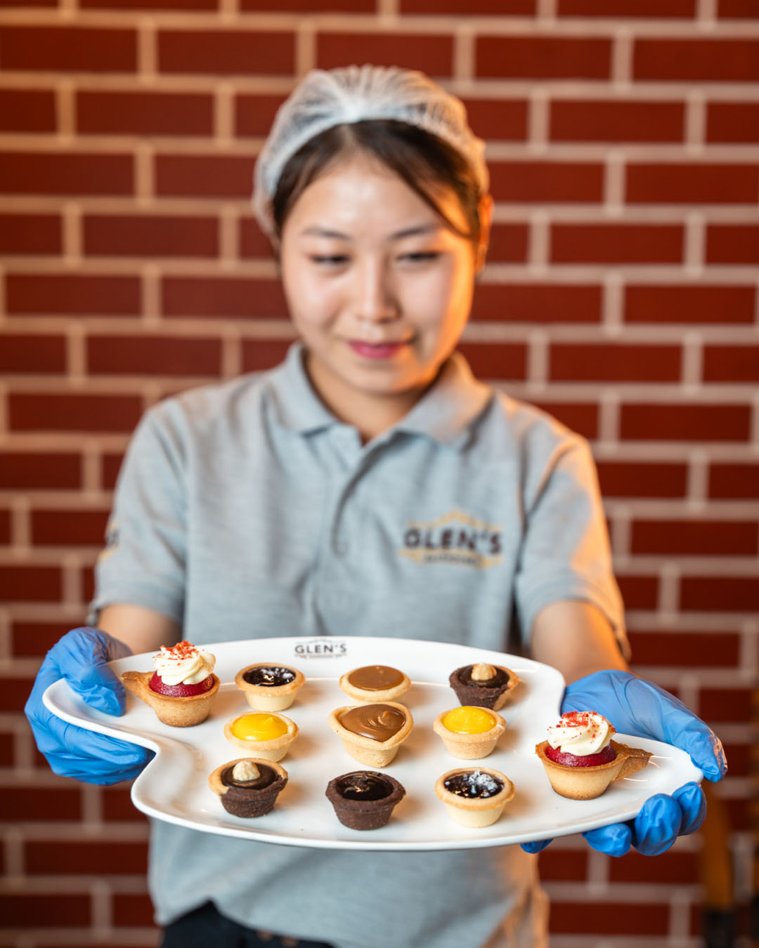 Glen’s Bakehouse team member presenting a platter of mini tarts